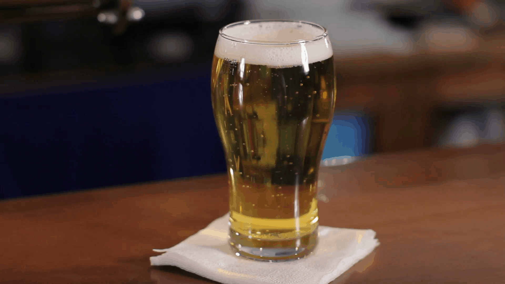 glass-of-beer-on-wooden-bar-counter-close-up-shot_sunpes8v__F0000