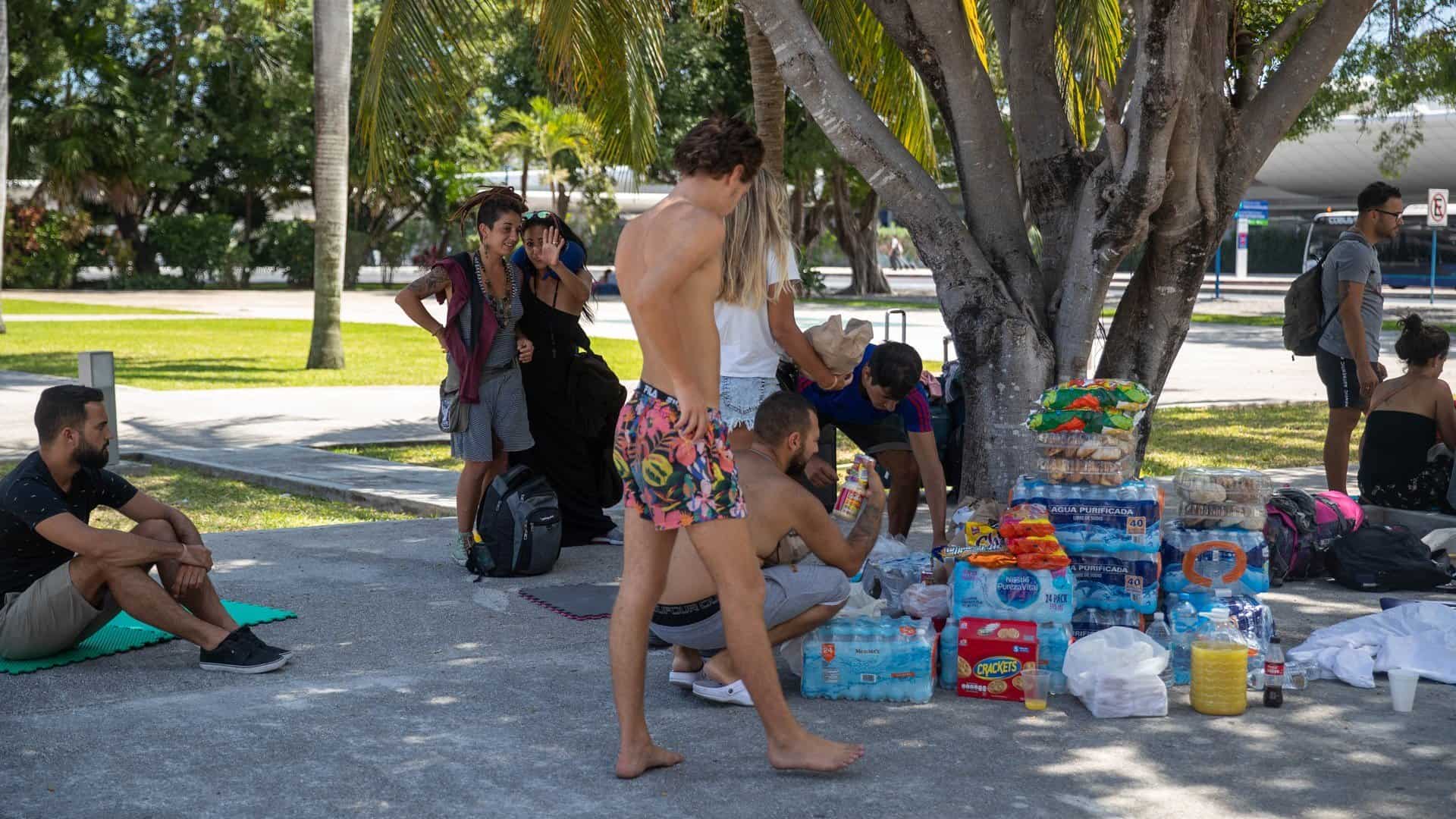 Turistas reciben alimentos y bebidas este martes en el aeropuerto internacional de Cancún, en el estado de Quintana Roo (México). EFE/Lourdes Cruz