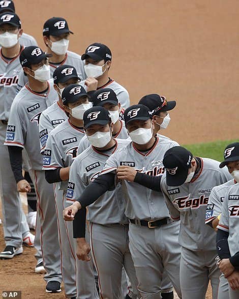 La Liga de Béisbol de Corea del Sur vuelve a jugar frente a espectadores de cartón image 28017870 8287509 Hanwha Eagles players wearing face masks line up during the star a 14 1588664251384