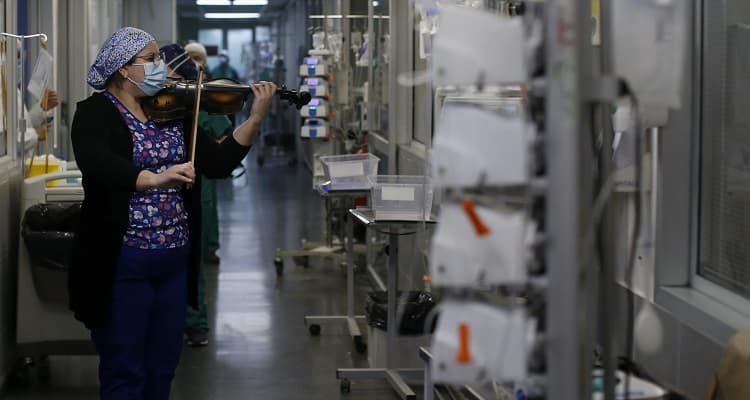 30 de Junio de 2020/SANTIAGO 
Todos los martes y jueves, Damaris Silva, quien trabaja como técnico en enfermería en el Hospital El Pino, toca su violín a pacientes internados en la Unidad de Cuidados Intensivos para levantar el ánimo y entregar esperanza, en medio de la crisis sanitaria provocada por la pandemia de COVID- 
19 en el país. 
FOTO:Cristobal Escobar/Agencia UNO