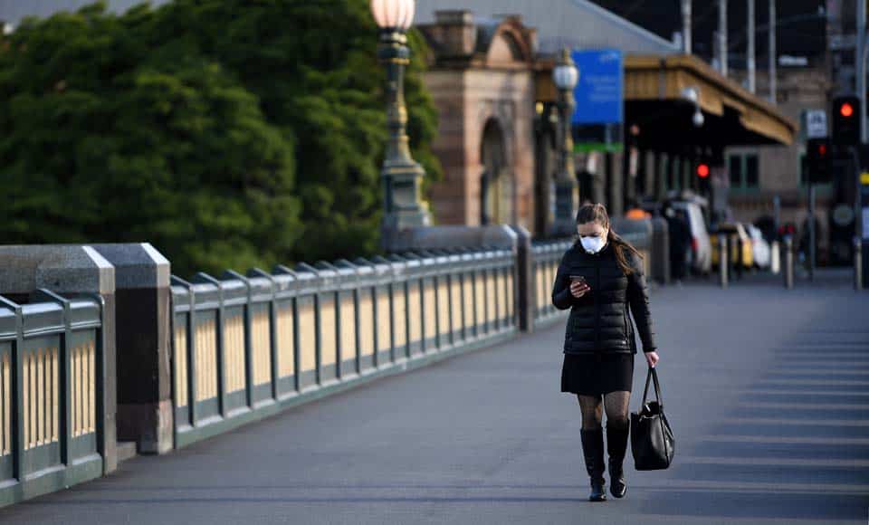 Melbourne (Australia), 02/08/2020.- A person wearing a face mask walks across Princes Bridge in Melbourne, Australia, 03 August 2020. Victorian Premier Daniel Andrews has foreshadowed major changes to workplace restrictions on 03 August, after Melburnians had their first night under curfew. EFE/EPA/JAMES ROSS AUSTRALIA AND NEW ZEALAND OUT