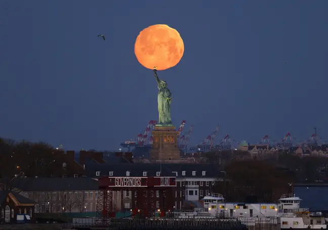 [IMÁGENES] Así se vio la superluna rosa en diferentes partes del mundo y en Nueva York, creando una aureola alrededor de la Estatua de la Libertad