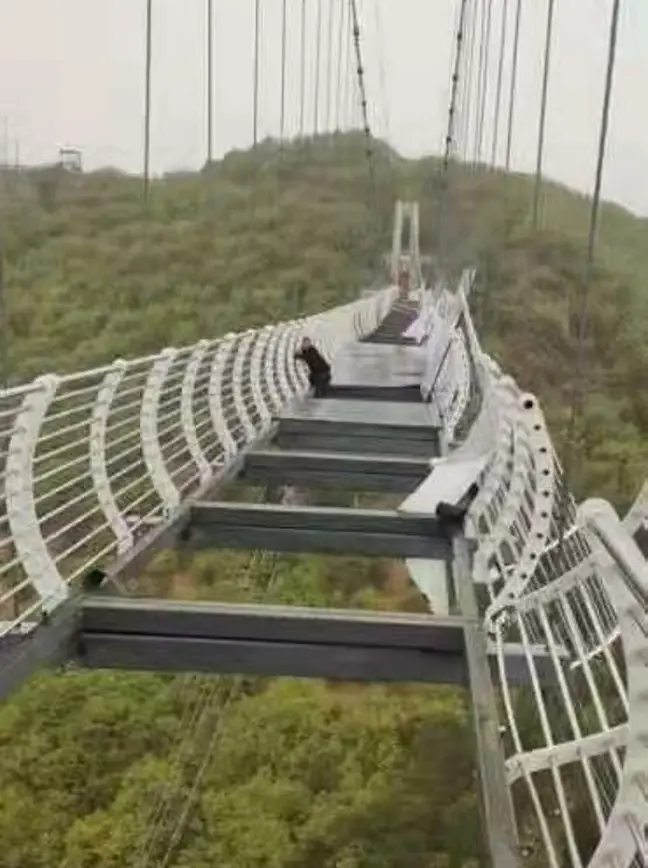 puente China: un turista quedó atascado en un puente de vidrio a 100 metros de altura luego de que un vendaval volara sus paneles China: Un Turista Quedó Atascado En Un Puente De Vidrio A 100 Metros De Altura Luego De Que Un Vendaval Volara Sus Paneles