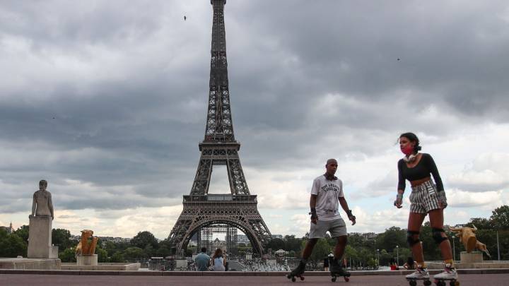 Personas patinando frente a la Torre Eiffel