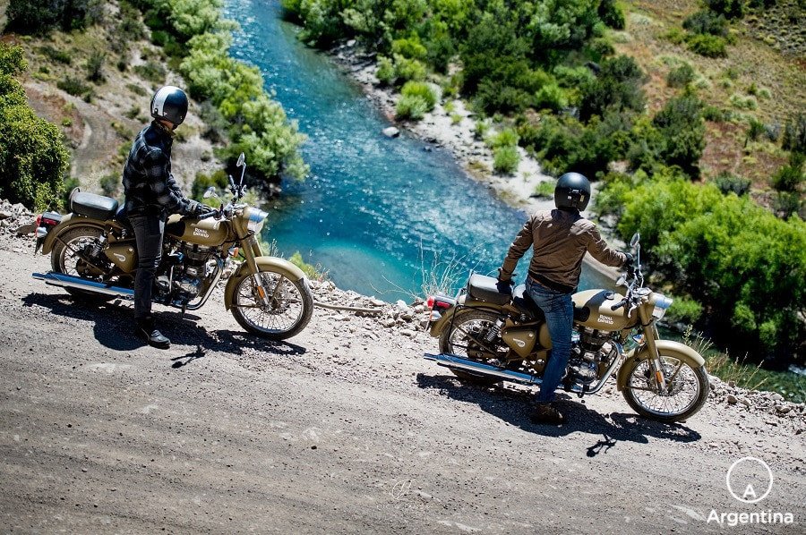 dos hombres en moto frente al río