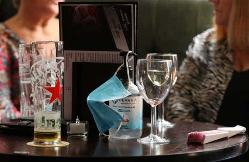 Barbijo y alcohol en gel sobre una mesa