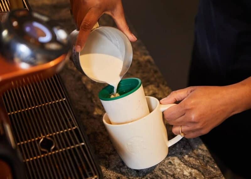 El barista prepara la vida con el vaso reutilizable en la taza