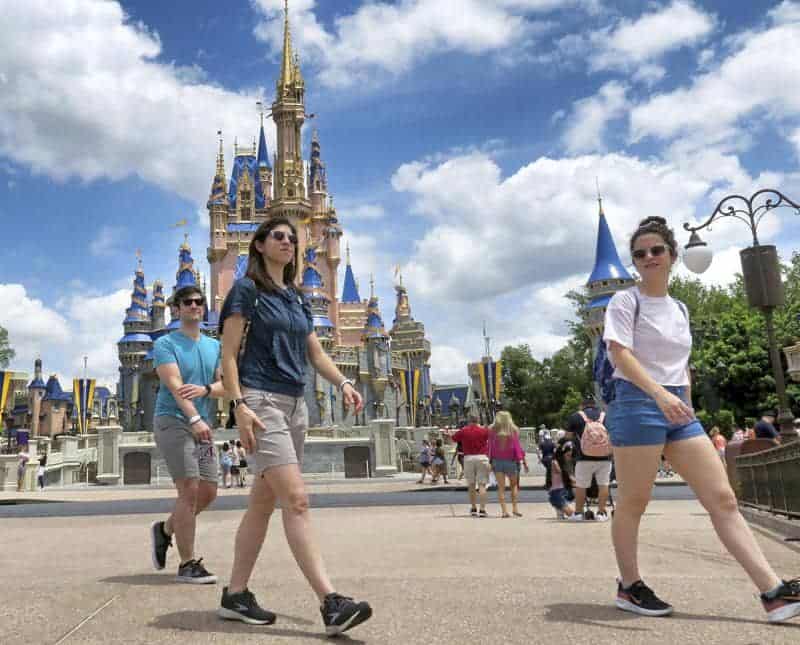 Personas caminando en Disney World, al aire libre, sin mascarilla