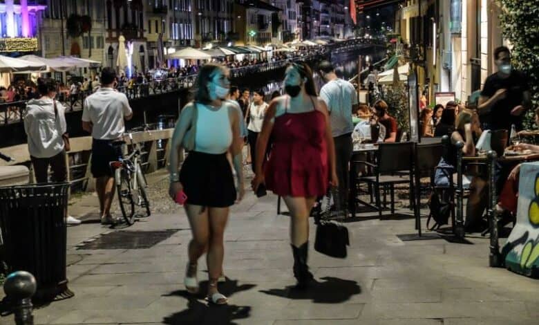 Personas caminando en Italia, donde ya no es obligatorio el uso de mascarilla en espacios al aire libre