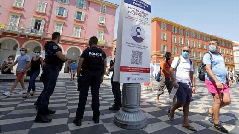 Personas al aire libre con mascarilla en Francia