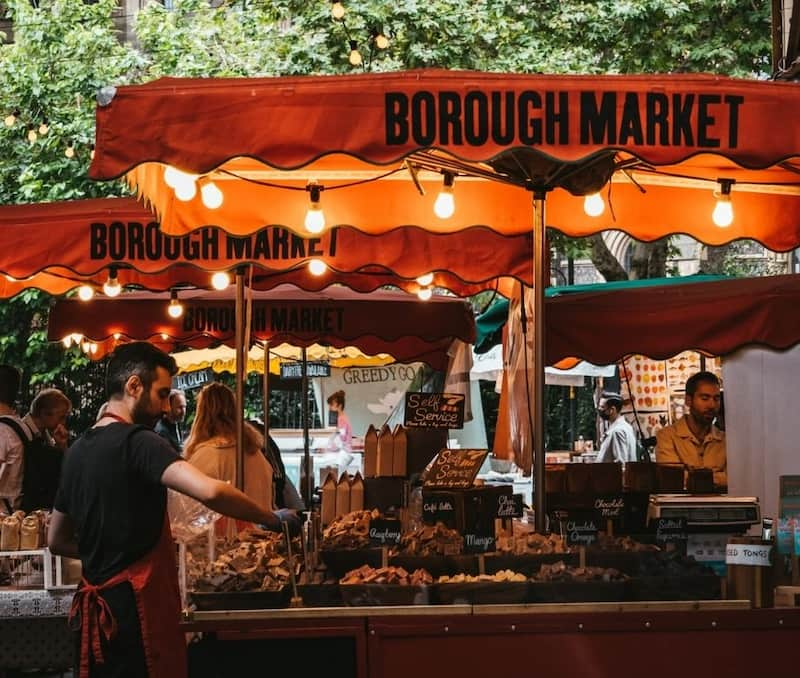 Persona atendiendo un puesto en Borough Market, Londres