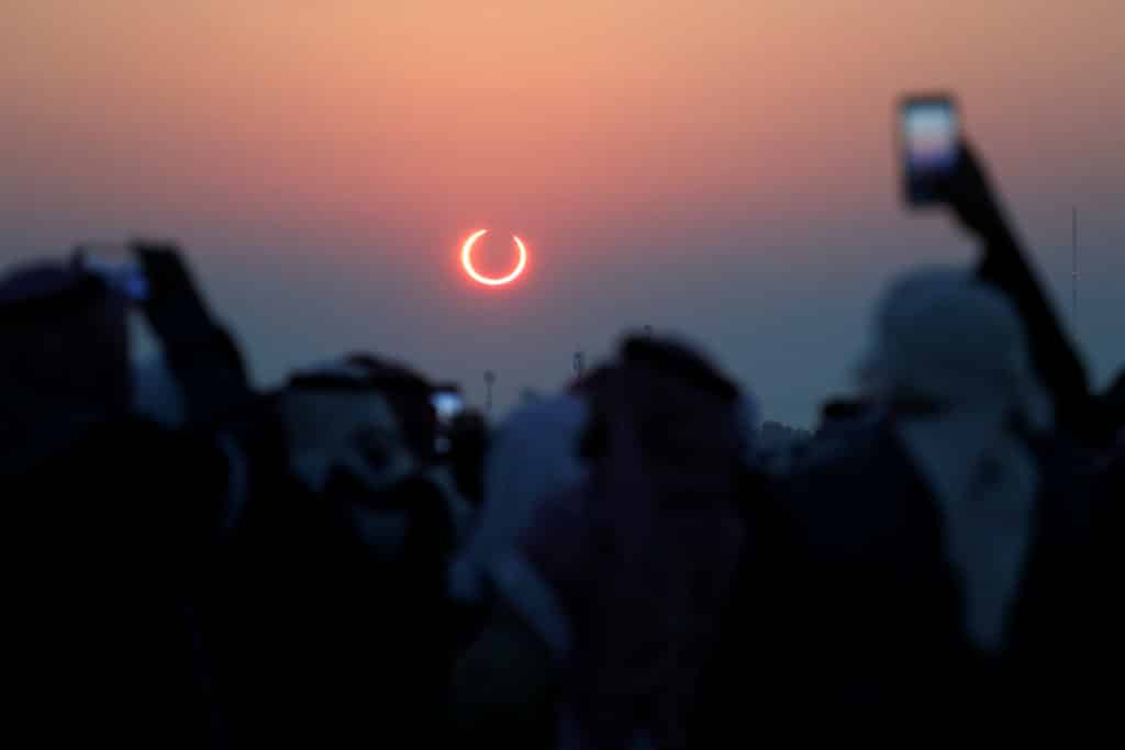 People take photos with their smartphones as they monitor the annular solar eclipse on Jabal Arba (Four Mountains) in Hofuf, in the Eastern Province of Saudi Arabia, December 26, 2019. REUTERS/Hamad I Mohammed