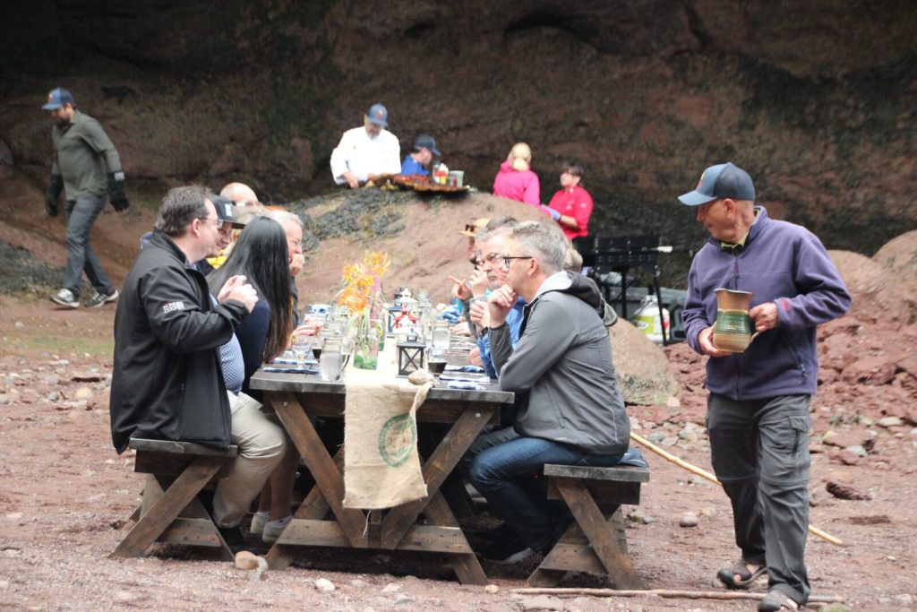 image Savor the Sea Caves communal dining table with chef in the background savour the sea caves 11