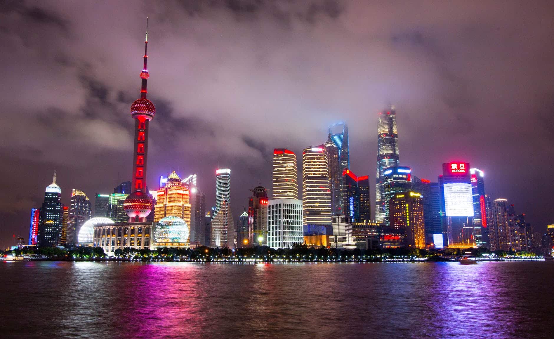 lighted buildings during nighttime near body of water