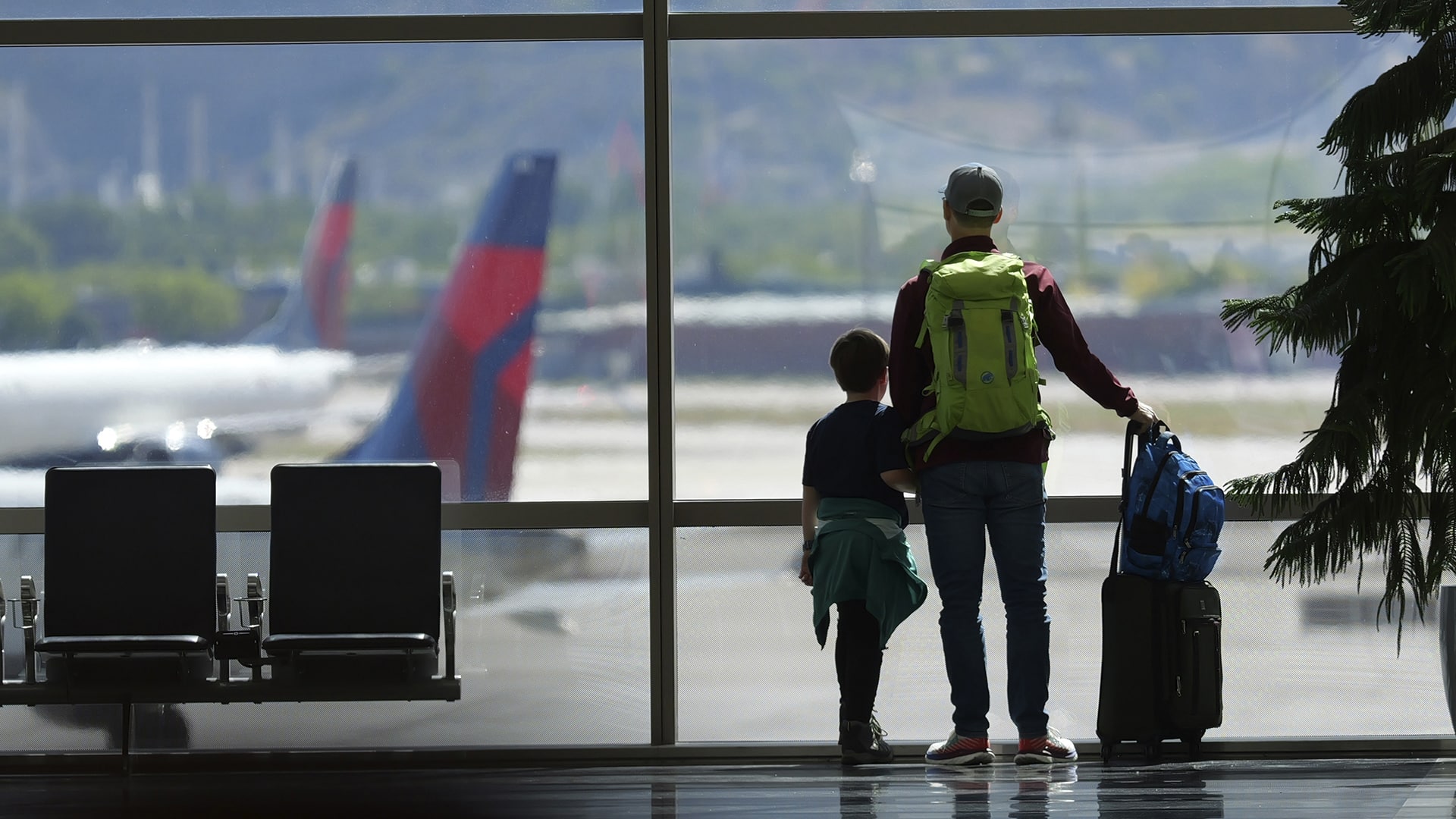 ARCHIVO - Pasajeros observan desde una ventana del Aeropuerto Internacional de Salt Lake City, el 24 de mayo de 2024. (AP Foto/Rick Bowmer, Archivo)