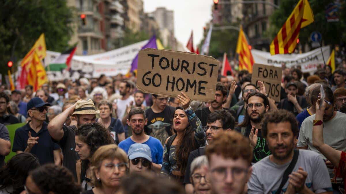 ARCHIVO - Manifestantes corean lemas contra el Formula 1 Barcelona Fan Festival en el centro de Barcelona, España, el miércoles, el 19 de junio de 2024, con protestas contra el turismo masivo. (AP Foto/Emilio Morenatti, Archivo)