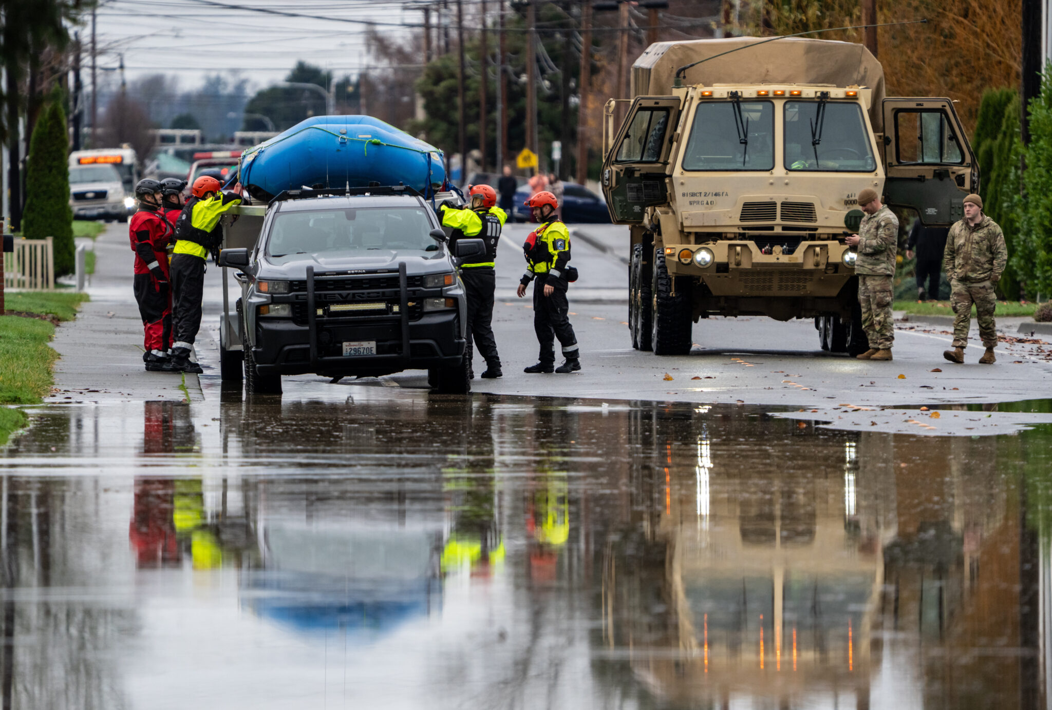 Equipos de emergencia, que incluyen a soldados de la Guardia Nacional, trabajan en un vecindario inundado por el río Skagit, el viernes 12 de diciembre de 2025, en Burlington, Washington. (AP Foto/Stephen Brashear)