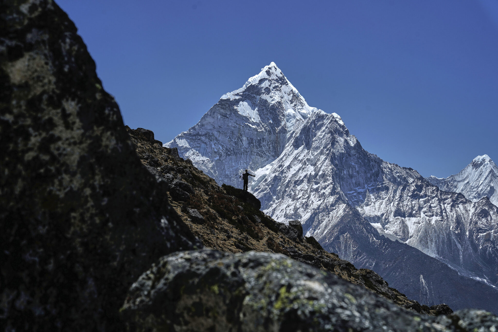 A mountaineer is silhouetted against Mount Ama Dablam on his way to the summit of Mount Everest in Nepal, April 24, 2025. (AP Photo/Pasang Rinzee Sherpa)