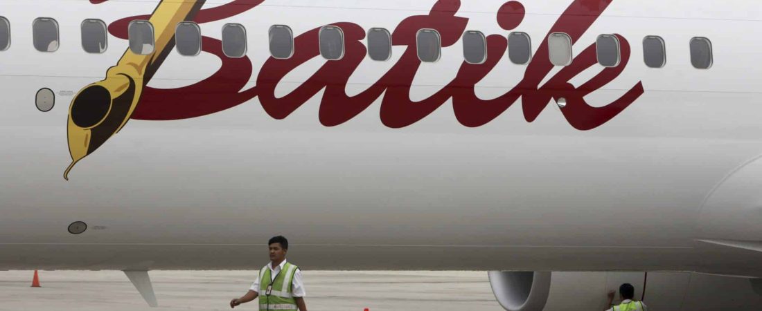 Trabajadores aeroportuarios caminan junto a un avión de Batik Air. EFE/ Adi Weda