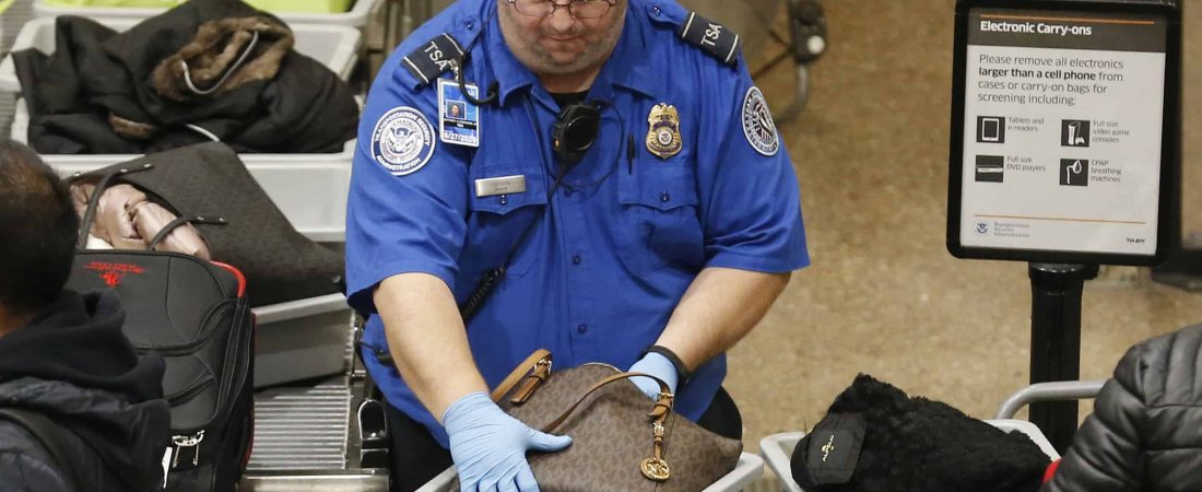 A TSA worker helps passengers at the Salt Lake City International Airport, Wednesday, Jan. 16, 2019, in Salt Lake City. The government shutdown has generated an outpouring of generosity to TSA agents and other federal employees who are working without pay. In Salt Lake City, airport officials treated workers from the TSA, FAA and Customs and Border Protection to a free barbecue lunch as a gesture to keep their spirits up during a difficult time. (AP Photo/Rick Bowmer)