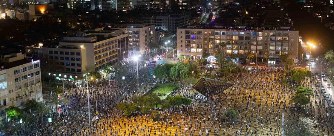 People keep social distancing amid concerns over the country's coronavirus outbreak, during a protest against Prime Minister Benjamin Netanyahu in Tel Aviv, Israel, Sunday, April 19, 2020. More than 2,000 people took to the streets on Sunday, demonstrating against Prime Minister Benjamin Netanyahu's attempts to form an "emergency" government with his chief rival and accusing him of using the coronavirus crisis to escape prosecution on corruption charges. (AP Photo/Oded Balilty)