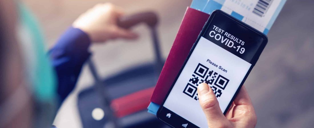 person in airport using mobile app in phone to show covid-19 test results for travel