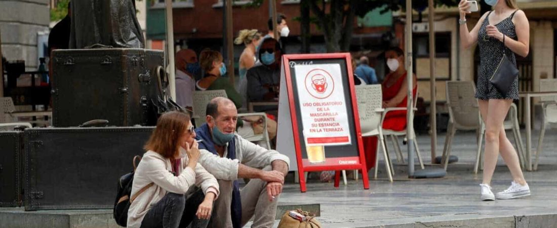 OVIEDO, 13/08/2020.- Una pareja de turistas fuman sentados en una plaza del centro de Oviedo, este jueves. El Gobierno asturiano está valorando "con prudencia" la posibilidad de prohibir fumar en la vía pública en función de cómo evolucione la pandemia de la covid-19 y desde la perspectiva jurídica para definir "hasta qué punto" se podría tomar esa decisión desde el ámbito competencial del Principado. EFE/Alberto Morante