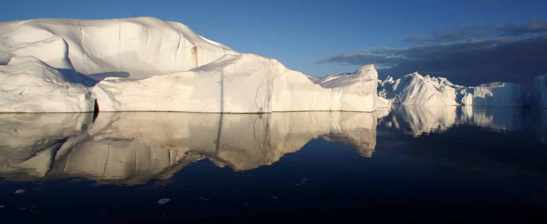 FILE PHOTO: Icebergs are reflected in the calm waters at the mouth of the Jakobshavn ice fjord near Ilulissat, Greenland, May 15, 2007.  REUTERS/Bob Strong/File Photo