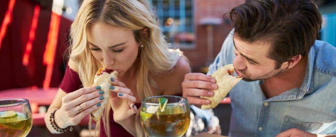 Two people eating tacos