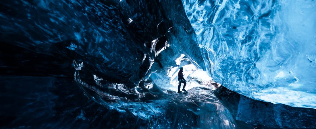 Inside an icecave in Vatnajokull, Iceland. A climber silhoutted against the ice. The ice is thousands of years old and so packed it is harder than steel and crystal clear. These caves are formed by meltwater that rushes from over and underneath the glacier and creates these wonderful sights