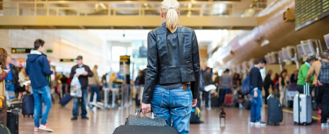 Female traveller walking airport terminal.