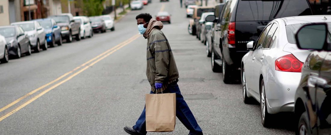 A man carries a bag containing meals, face masks and other personal protective supplies during a distribution to residents in need outside the NAN Newark Tech World during the outbreak of the coronavirus disease (COVID-19) in Newark, New Jersey, U.S., May 6, 2020. REUTERS/Mike Segar - RC25JG9FG201