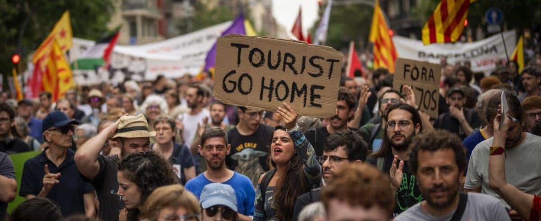 ARCHIVO - Manifestantes corean lemas contra el Formula 1 Barcelona Fan Festival en el centro de Barcelona, España, el miércoles, el 19 de junio de 2024, con protestas contra el turismo masivo. (AP Foto/Emilio Morenatti, Archivo)