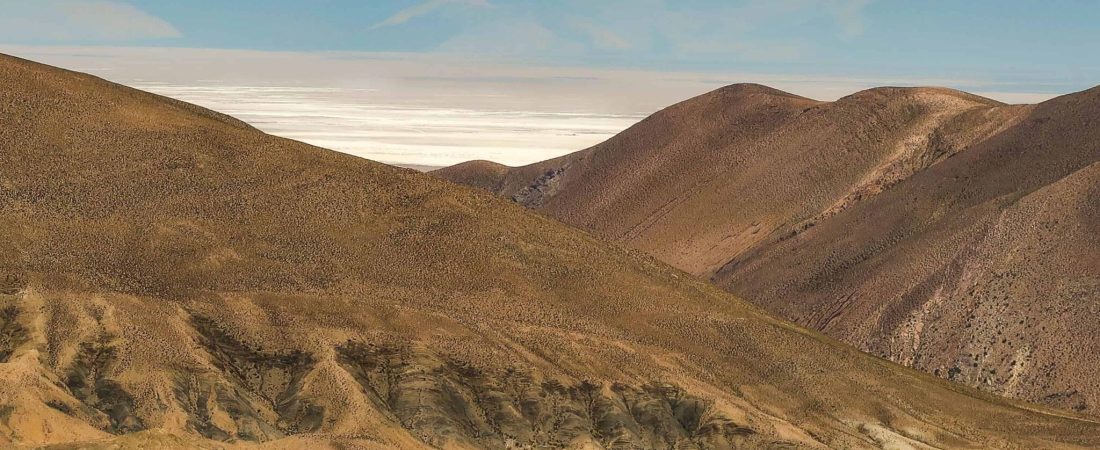 brown mountains near body of water during daytime