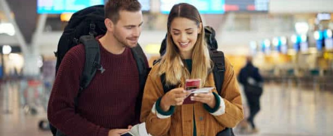 Happy couple, airport and phone with ticket, travel app and adventure with excited face, conversation and smile. Man, woman and smartphone for digital booking of hotel, taxi or bus for transportation