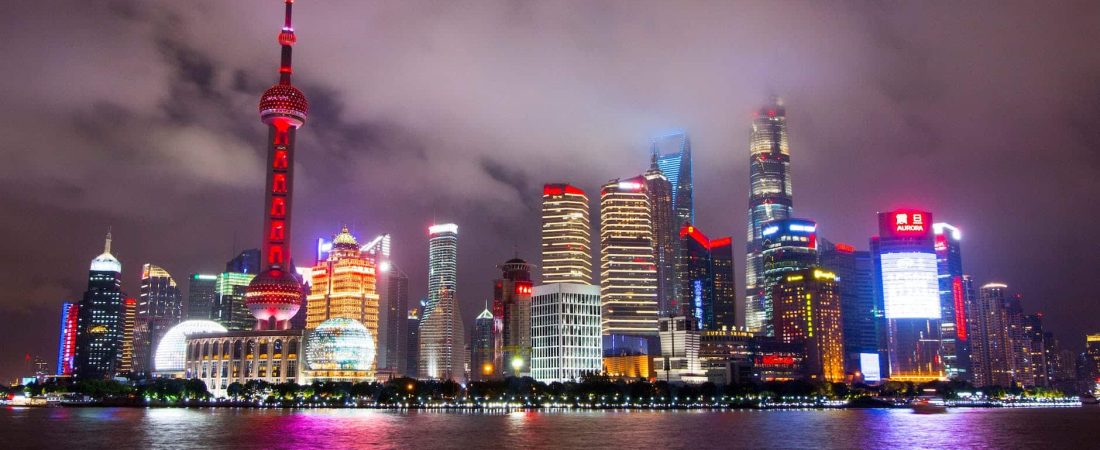 lighted buildings during nighttime near body of water