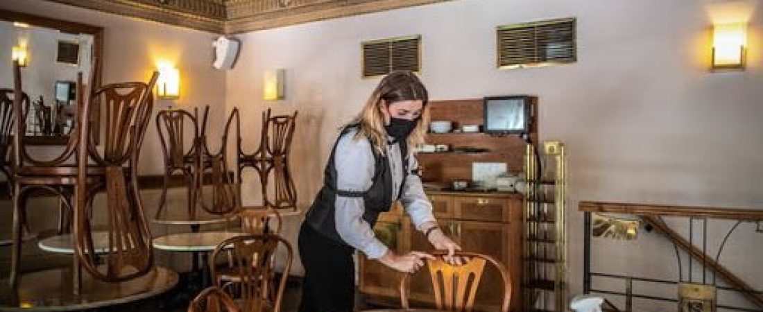 epa08441693 A waiter wearing a protective face mask arranges the furniture ahead of the reopening of the Cafe Savoy in Prague, Czech Republic, 24 May 2020. Starting on 25 May, restaurants and cafes across the country will be allowed to again serve seated customers indoors as the next phase of the lifting of coronavirus-induced restrictions kicks off. The Czech government is gradually easing the lockdown measures it had imposed back in March in a bid to slow down the spread of the pandemic COVID-19 disease caused by the SARS-CoV-2 coronavirus.  EPA/MARTIN DIVISEK