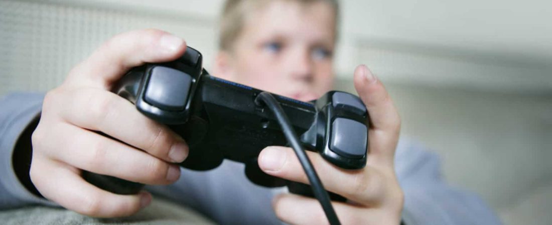 Boy (9-11) playing games console (focus on hands and control)